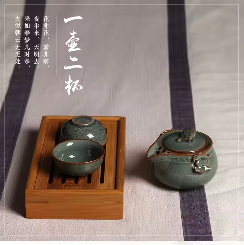 Full Longquan celadon tea set with gaiwan and two cups on fabric background