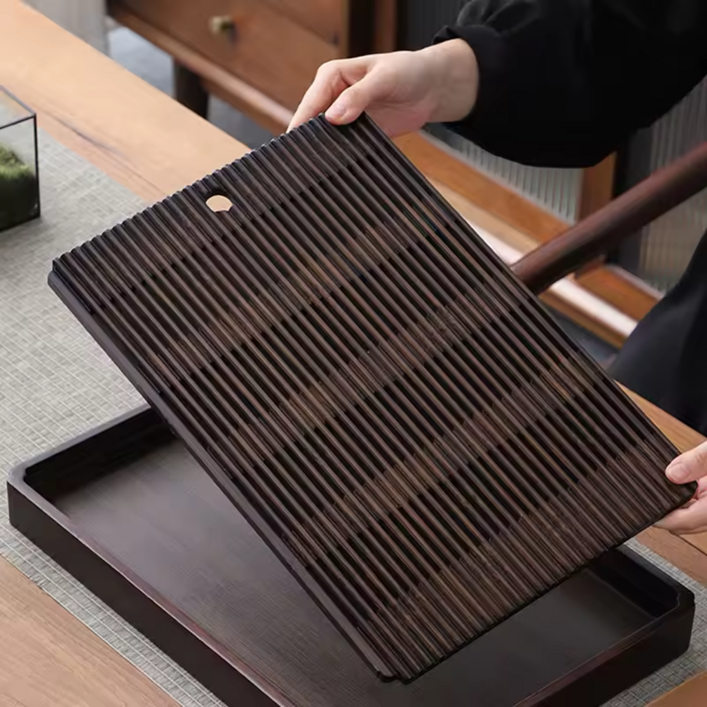 Person lifting the slatted bamboo top from rectangular tea tray