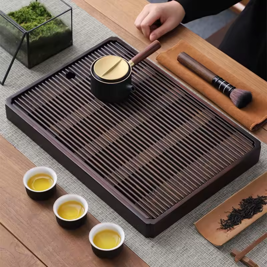 Large rectangular bamboo tea tray on wooden table viewed at an angle