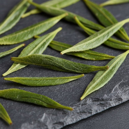 Green tea leaves on a dark slate surface