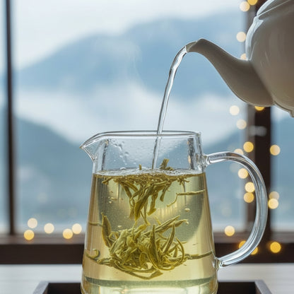 Tea being poured into a glass pitcher with a blurred background