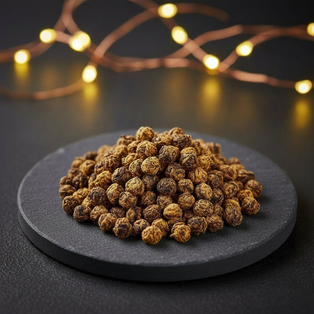 Pile of dried berries on a dark surface with warm string lights in the background